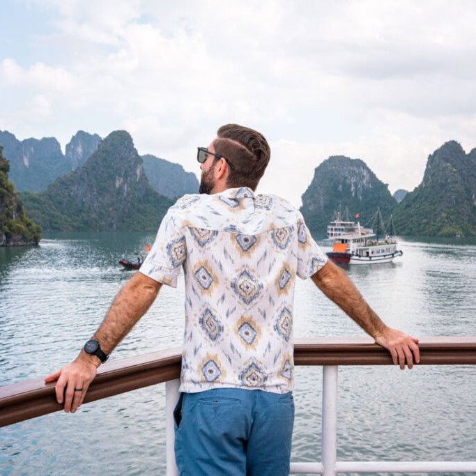 Man on a boat deck looking out over Ha Long Bay